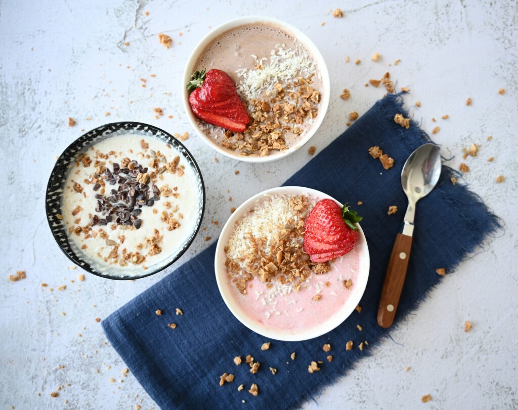 kvarg och overnight oats med jordgubbar, granola och kokos på ett bord